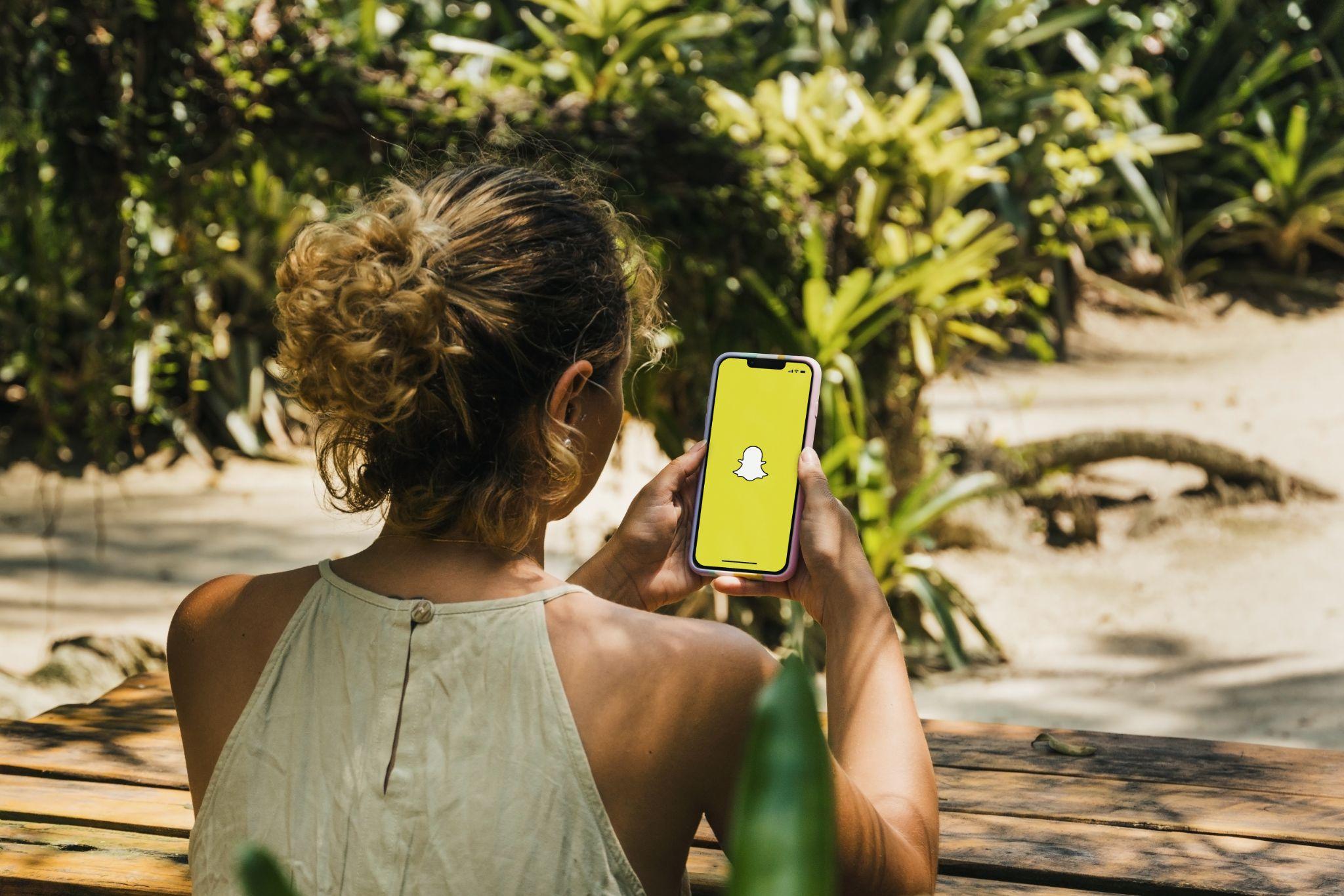 girl holding phone with snapchat app