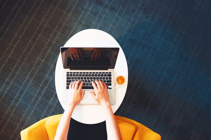 Freelance writer working on laptop at coffee shop representing remote work lifestyle